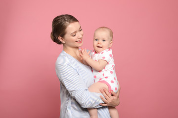 Canvas Print - Portrait of happy mother with her baby on color background