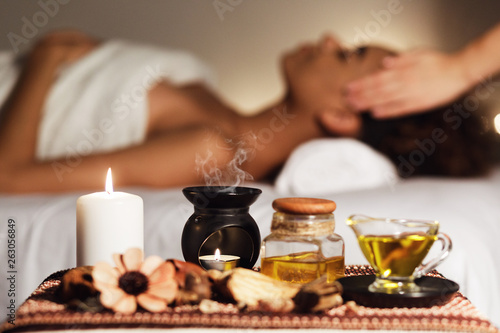 Fotomural African woman having face massage, relaxing in spa salon