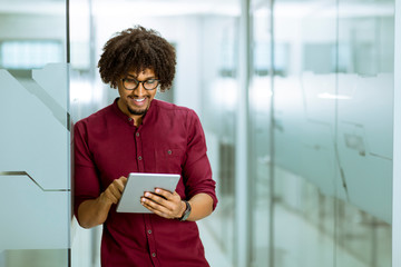 African-american young businessman with tablet standing in the office