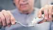 © sebra - Man extrude a toothpaste from a tube on a toothbrush