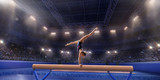 Female athlete doing a complicated exciting trick on gymnastics balance beam in a professional gym. Girl perform stunt in bright sports clothes
