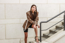 Portrait Shooting Of A Stylish Girl. Beige Shades. Trends Of Spring And Summer 2019. Bike Shorts. Thick Cloak, Cover Jacket. Gold Earrings. Heels