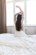 © F8  \ Suport Ukraine - Young woman stretching in the bed after wake up in the morning
