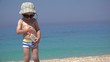 © MEDIAIMAG - Funny little child with sunglasses and hat applying sun cream on his body