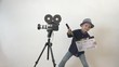 © MEDIAIMAG - Funny child holding a clapboard, little director having fun, old camera, action