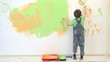 Little artist painting white wall, amusing child have fun