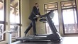 © MEDIAIMAG - Man with suit running on gym machine, work break, running to succes