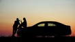 © MEDIAIMAG - Couple of lovers silhouette drink champagne at sunset, woman sit on car, romantic evening