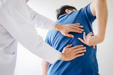 Doctor Physiotherapist Treating Lower Back Pain Patient After Exercising