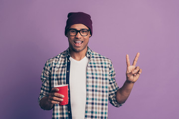 Wall Mural - Closeup portrait of crazy carefree positive glad cool in modern clothes guy holding saying cheers clink toast to you showing v-sign symbol isolated violet background