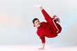 © alfa27 - Stylish dressed in red sweatpants asian b-boy is performing kick in air, standing on hands while dancing break dance on white background. Freestyler doing air baby freeze