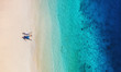 Aerial view of a people couple on the beach on Bali, Indonesia. Vacation and adventure. Beach and turquoise water. Top view from drone at beach, azure sea and relax couple. Travel and relax - image