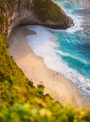 Canvas Print - View of a people couple on the beach on Bali, Indonesia. Vacation and adventure. Beach and turquoise water. Top view from drone at beach, azure sea and relax couple. Travel and relax - image