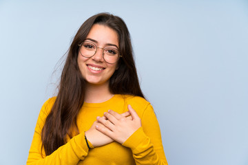 Wall Mural - Teenager girl over isolated blue wall in love