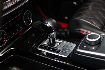 Poster - The interior of the car with a view of the steering wheel, dashboard, seats and multimedia system with black leather and red thead rombus trim