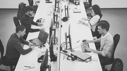 young professionals working in modern office. group of developers or programmers sitting at desks fo