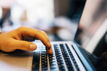 Wall Mural - Sideview of male using laptop on desk top