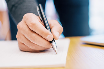 Sideview of male doing paperwork with laptop