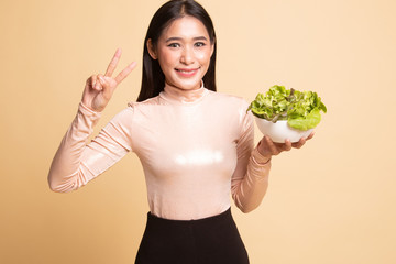 Healthy Asian woman show victory sign with salad.