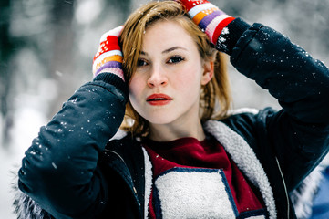 Wall Mural - Portrait of a beautiful girl in the black jacket with fur hood amid winter forest