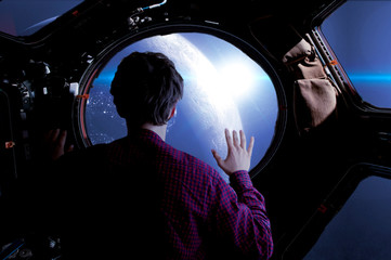 young space tourist in front of the space shuttles windows. elements of this image furnished by nasa