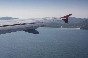 flying and traveling abroad, bird eye view from airplane window on the jet wing on wonderful island beach in vacation summer, journey backgrounds