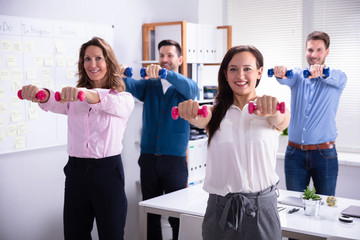 Wall Mural - Businesspeople Exercising With Dumbbells