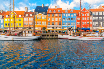 Wall Mural - Nyhavn area of popular bar and restaurant at beautiful blue sky, with colorful facades of old houses and old ships in the Old Town of Copenhagen, capital of Denmark.