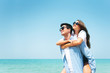 © eggeeggjiew - Happy Young couple wear sunglasses having fun on blue sky and the beach.