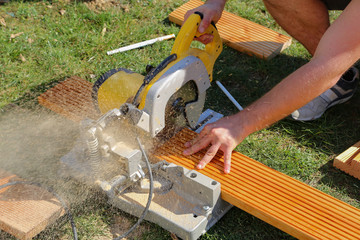 Wall Mural - A worker saw wood with a chop saw