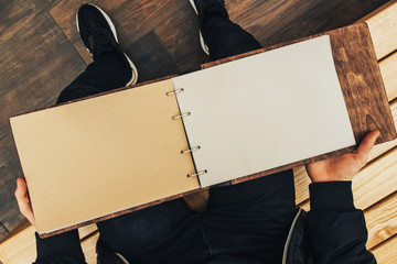 Wall Mural - The guy holds an empty vintage book made of wood