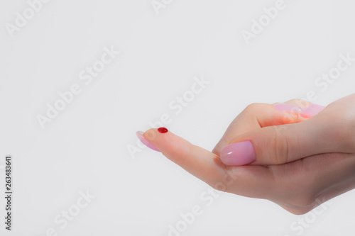 Fotomural red drop of blood on the finger, female hand, blood test, unexpected cut, blood