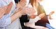 © rogerphoto - Business people clapping and applause at meeting or conference, close-up of hands. Group of unknown businessmen and women in modern white office. Success teamwork or corporate coaching concept