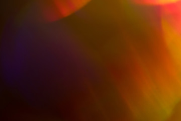 Wall Mural - blurry orange lights on dark background. defocused lens flare glow. abstract design.