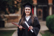 © Тарас Нагирняк - Female student graduate is standing in university hall in mantle, smiling and looking at the camera with diploma on hands!