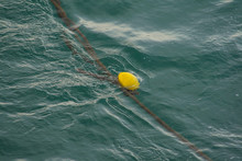 A Yellow Buoy Floating In The Sea