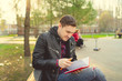© Anton Dios - Man with a notebook in his hands in the Park. Male, student is writing her ideas and thoughts into the notebook sitting on the bench in the park