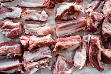 Wall Mural - Raw pork ribs chopped in pieces on the white table high angle view