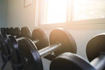 Rows of black dumbbell set on rack in the gym. Weight Training Equipment. Health care concept.