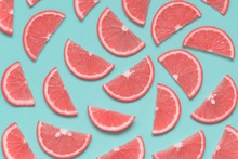 Creative Summer Pattern With Grapefruit Slices On Pastel Blue Background. Minimal Healthy Food, Color Trend Concept. Pop Art Style. Top View, Flat Lay.