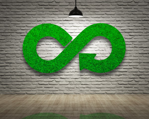 Wall Mural - Green Eco-friendly and circular economy concept. Infinity arrow recycling symbol of green grass texture on bricks wall with ceiling lamp of white light and wooden floor.