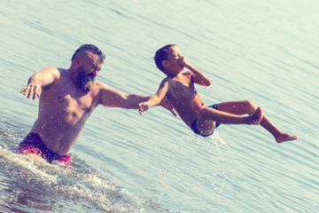 Jumping in the water. Man and boy are having fun and splashing in the water. Summer holiday concept