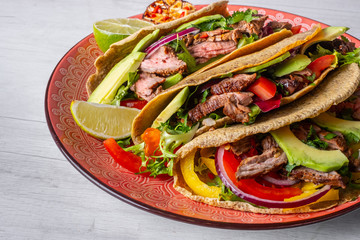 Wall Mural - Tacos with grilled meat, avocado, fresh salsa sauce and limes over rustic background. Healthy low carb and low fat lunch or food for company. Dieting and weight loss concept