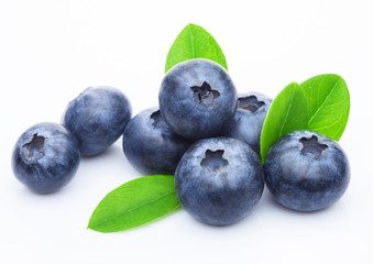 Wall Mural - Fresh raw organic blueberries with leaf on white background. Macro close up