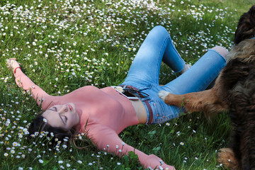 woman lying in a field of daisies in relax  protect by her dog