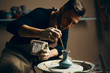 © GVS - Man painting handmade pottery at ceramic workshop