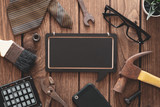 Fototapeta  - Labor Day and father's day background concept. Flat lay of construction blue collar handy tools and white collar's accessories over wooden background with black chalkboard. 