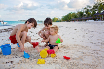 Wall Mural - Cute baby boy playing with beach toys on tropical beach