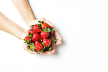 Wall Mural - Ripe local produce organic strawberry. Young woman holding heap of red berries in bare hands. Fresh healthy vegan dietary food for spring detox. Fruits background, top view. Clean eating concept.