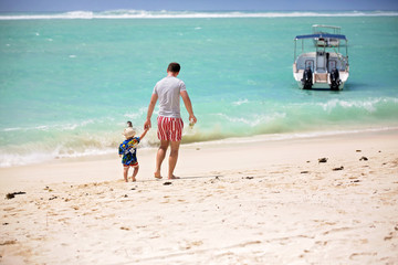 Canvas Print - Father and child, boys, having fun on ocean beach. Excited children playing with waves, swimming, splashing happily